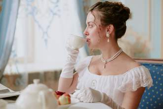 young woman drinking tea while sitting in elegant room