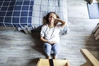 young woman suffering from pains holding her head and stomach