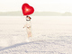 a dog in snow jumping to grab a heart shaped balloon the snow and heart balloon indicate that the month being represented is april and the dog is just kinda cute
