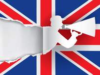 silhouette of a man with a megaphone against a british flag 